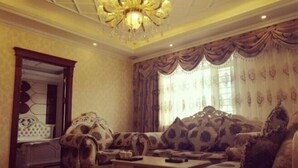 A luxurious living room with ornate furniture, a chandelier, and a large mirror. - Wanhao Business Hotel (New Barag Right Banner)