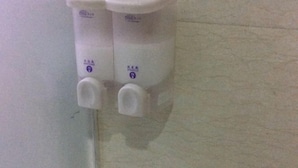 A wall-mounted dispenser with two pumps, likely for hand sanitizer or soap. - Sinan Yulan Business Hotel (Sinan)