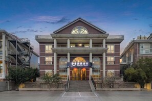 A building with a central entrance, a staircase on the left, and a symmetrical facade with windows. - Zanzan Hotel (Yantai)