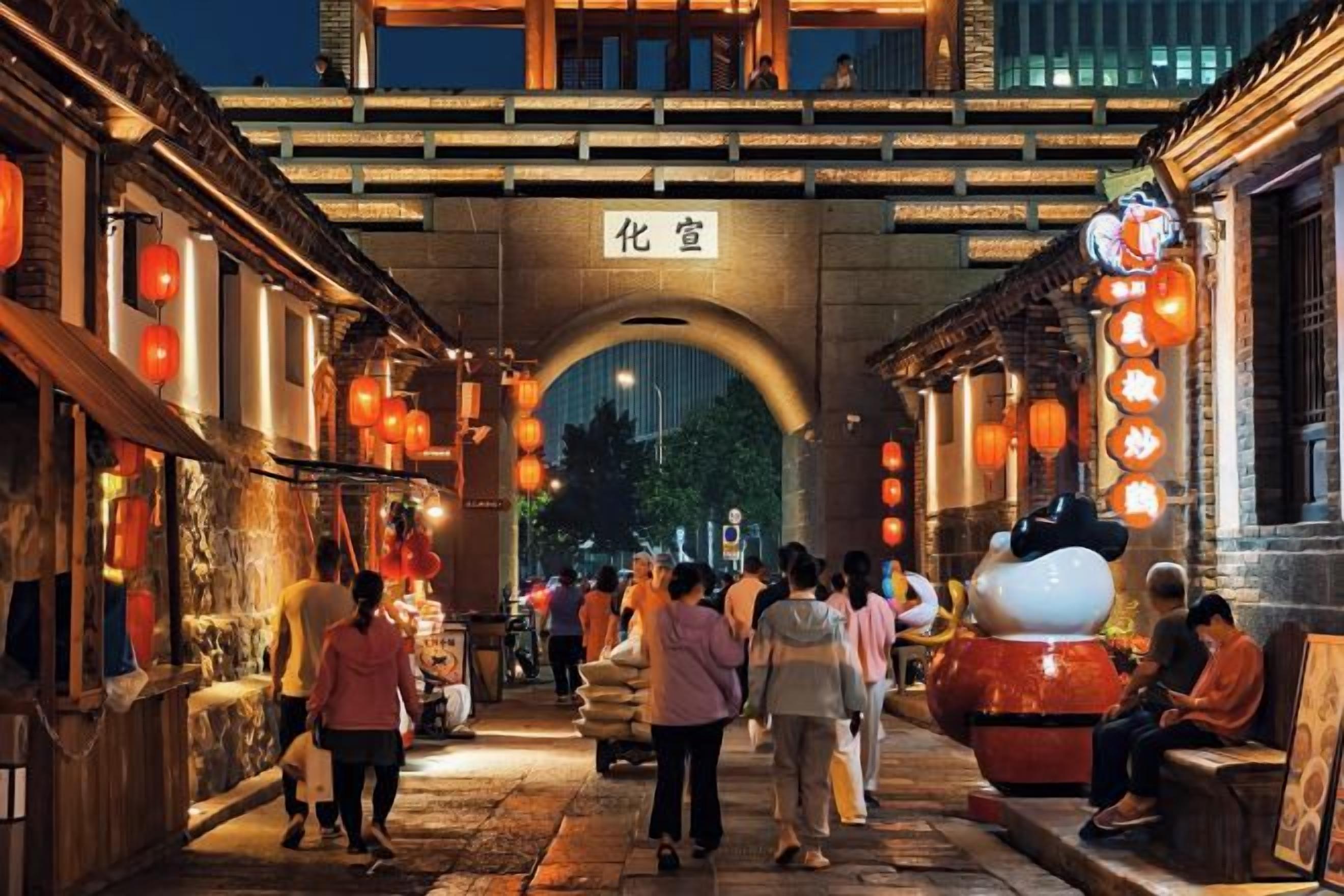 A traditional street with an arched entrance, lanterns, and people walking.