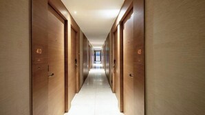 A corridor with wooden doors, each marked with a number. - Zanzan Hotel (Yantai)
