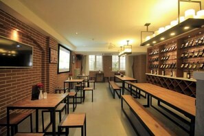 A restaurant interior with brick walls, wooden tables, and a television mounted on the wall.