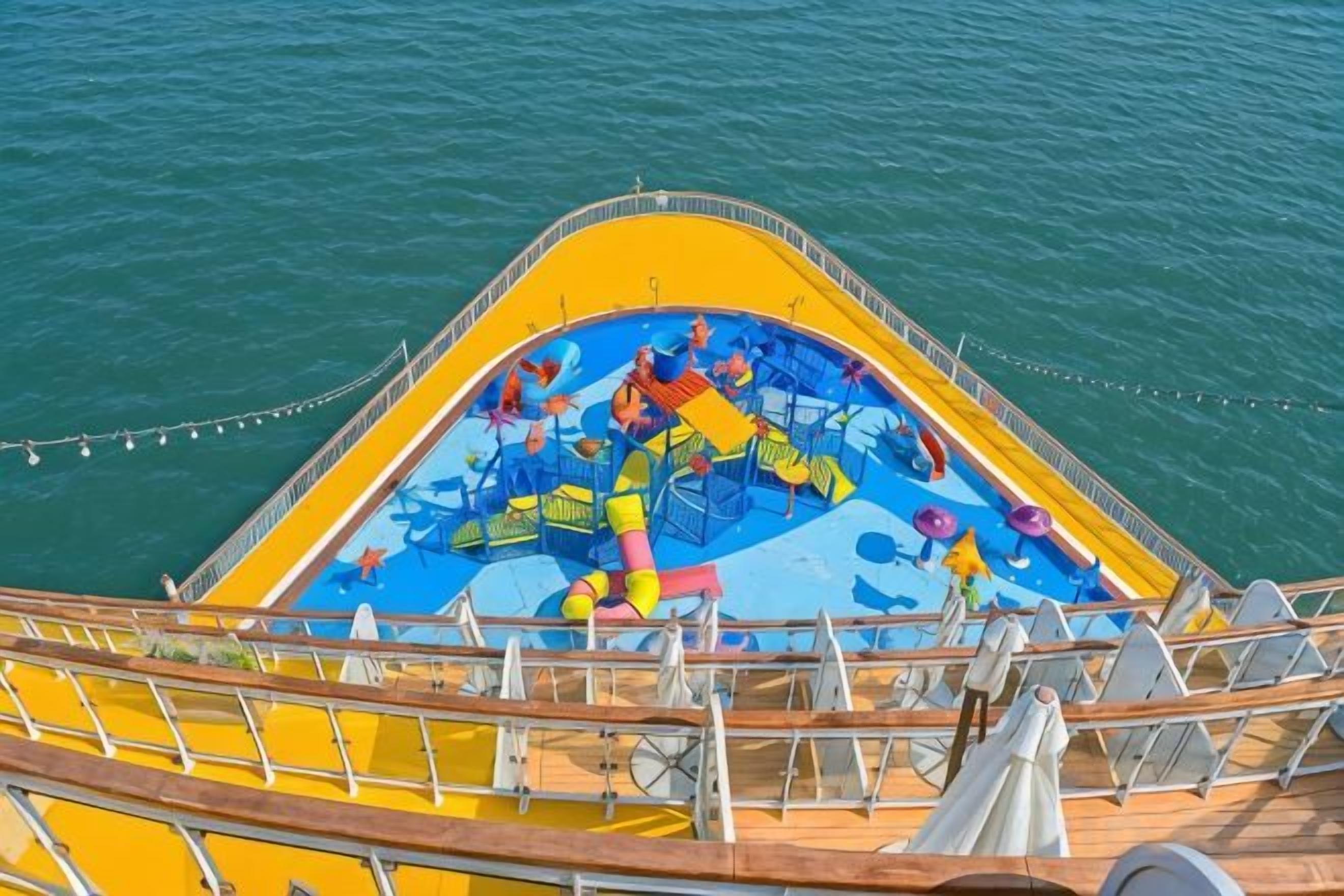 Cubierta de barco con piscina, boyas salvavidas y barandilla.