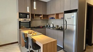 Een moderne keuken met inbouwapparatuur, een houten keukeneiland en een roestvrijstalen koelkast.