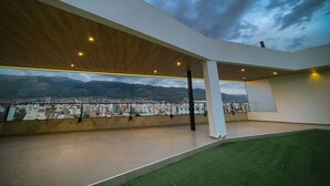 Un vaste espace intérieur offrant une vue sur la ville et les montagnes.