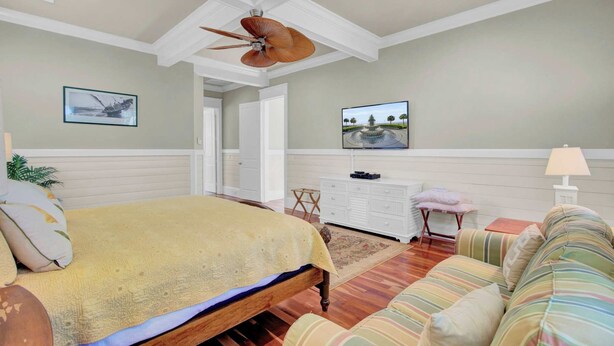 A bedroom with a bed, a ceiling fan, a television, a dresser, and a window. - POOL, ROOF DECK, ELEVATOR, 5 MIN TO THE SURF! (Isle of Palms)