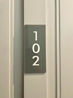 A close-up of a door with a number plate displaying the numbers 102. - Double One Coliving and Coworking Hostel (Makati)