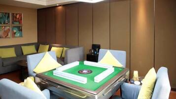 A room with a green pool table, sofas, and a coffee machine.