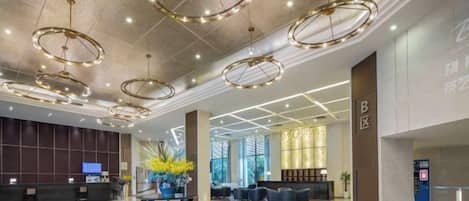 A spacious lobby with a reception desk, seating area, and modern lighting fixtures.