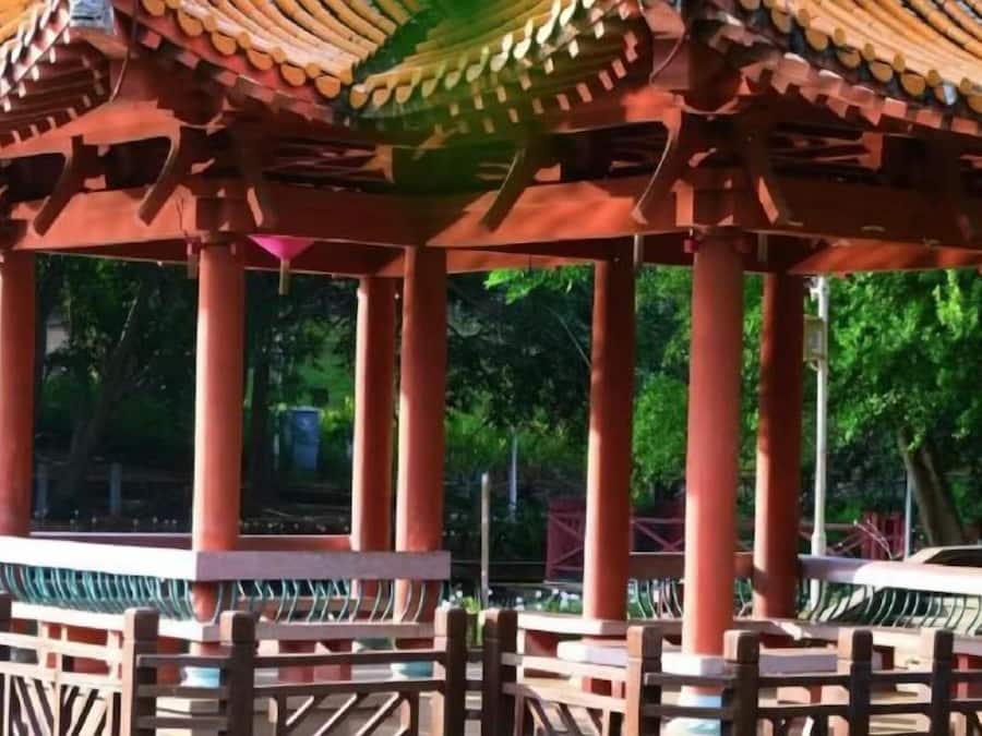A traditional pavilion with a tiled roof and wooden pillars.