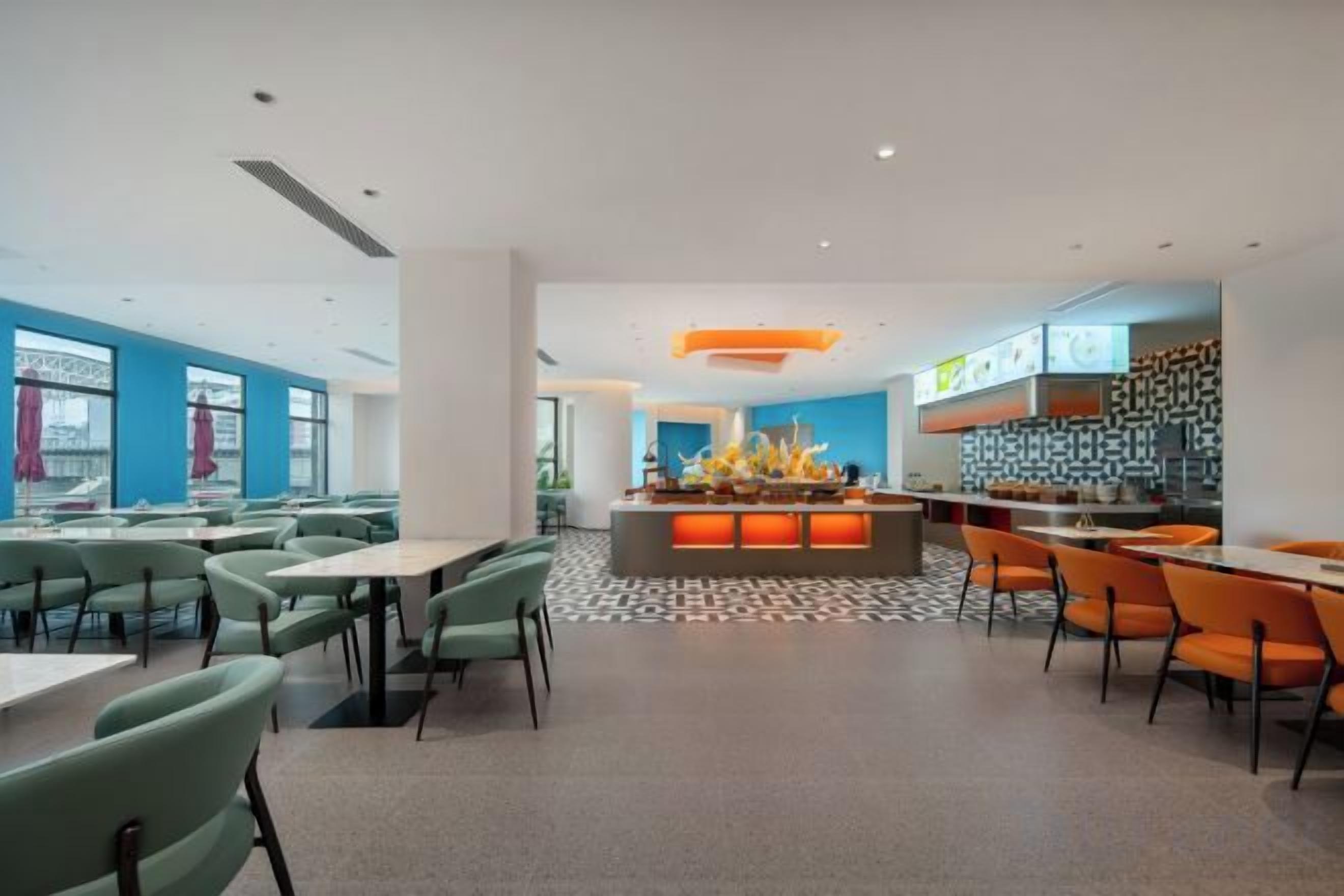 A modern dining area with tables and chairs, a central bar area, and a patterned floor.