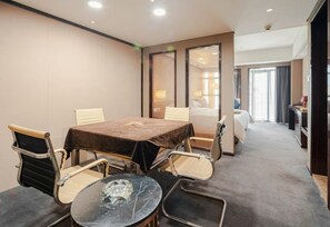 Habitación de hotel con una mesa de conferencias, dos sillas, una cama y un escritorio.