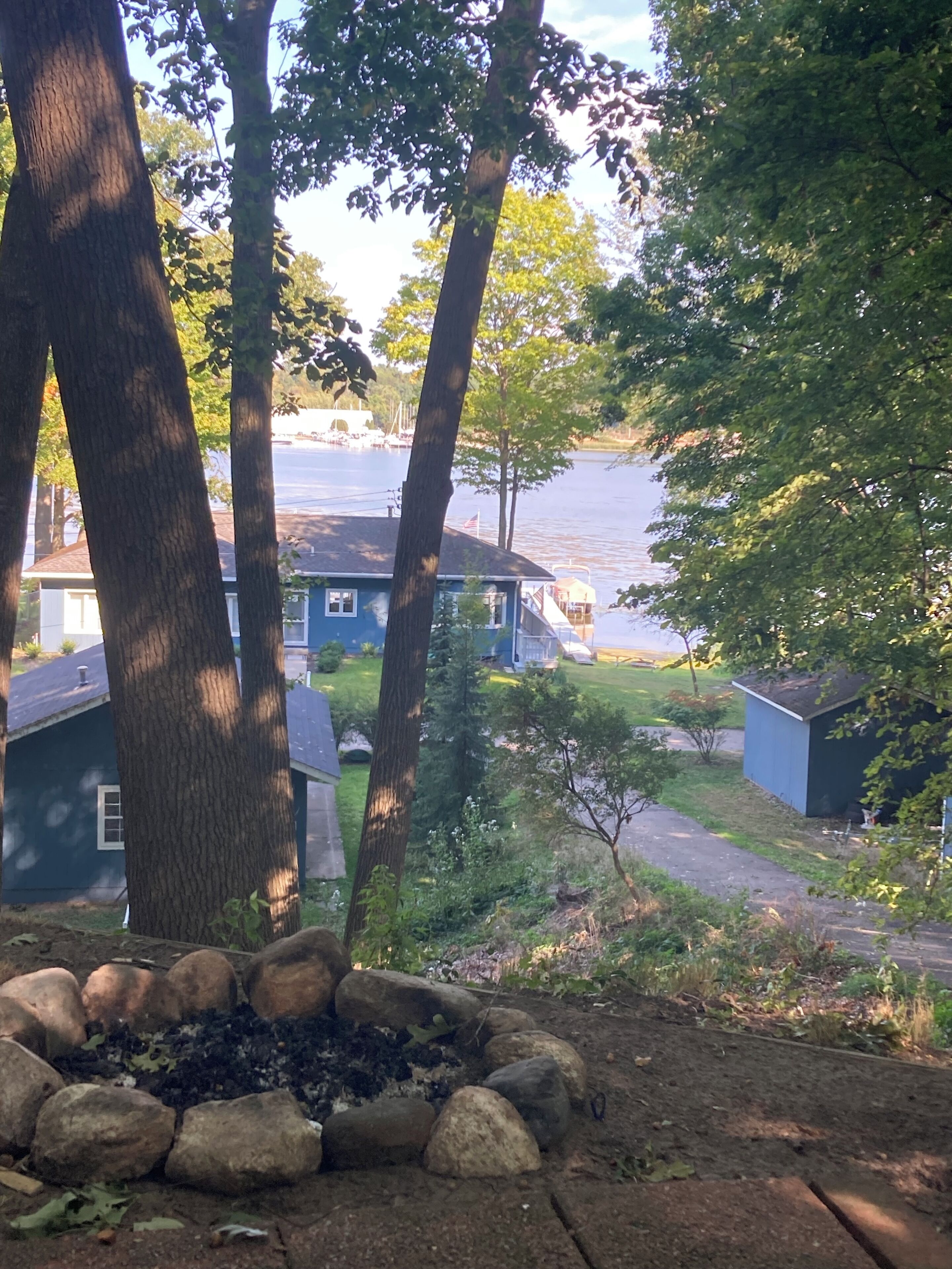 Área residencial com vista para um lago, casas e uma fogueira.