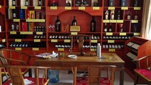 Ein Weinkeller mit Regalen voller Weinflaschen und einem Holztisch mit Stühlen.
