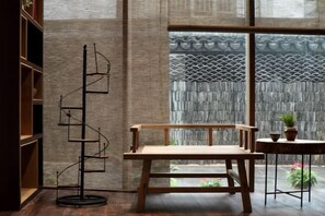 A room with a wooden bench, a floor lamp, and a view through a large window. - Shuiyunju Boutique Hotel (Tongxiang)