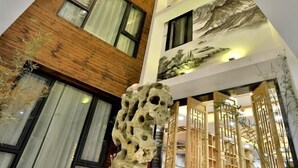 A multi-level building with wooden and white facades, large windows, and traditional Chinese architectural elements. - Shuiyunju Boutique Hotel (Tongxiang)