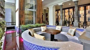A circular seating area with a table, cushioned benches, and a tiled floor. - Shuiyunju Boutique Hotel (Tongxiang)