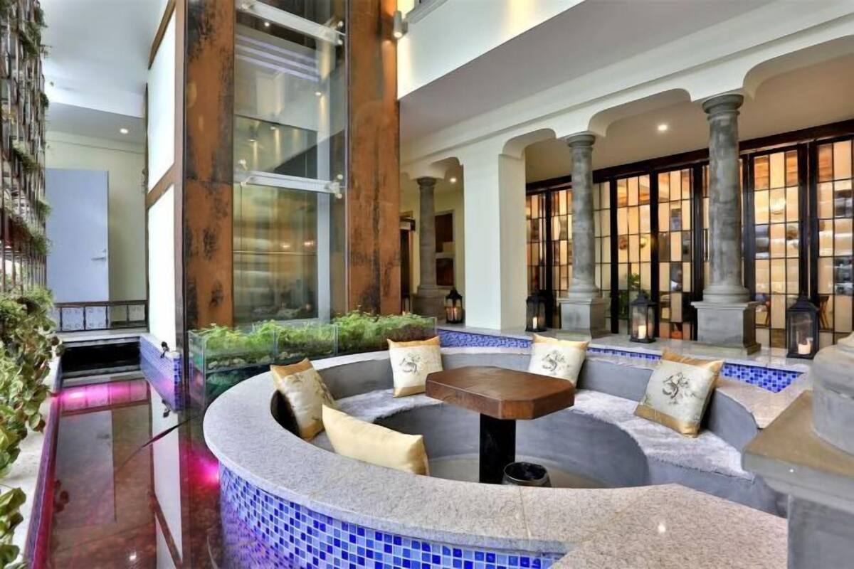 A circular seating area with a table, cushioned benches, and a tiled floor.