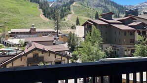 A mountain resort with buildings, a ski slope, and a pool.