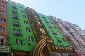 Un edificio de varios pisos con un llamativo letrero negro y amarillo.