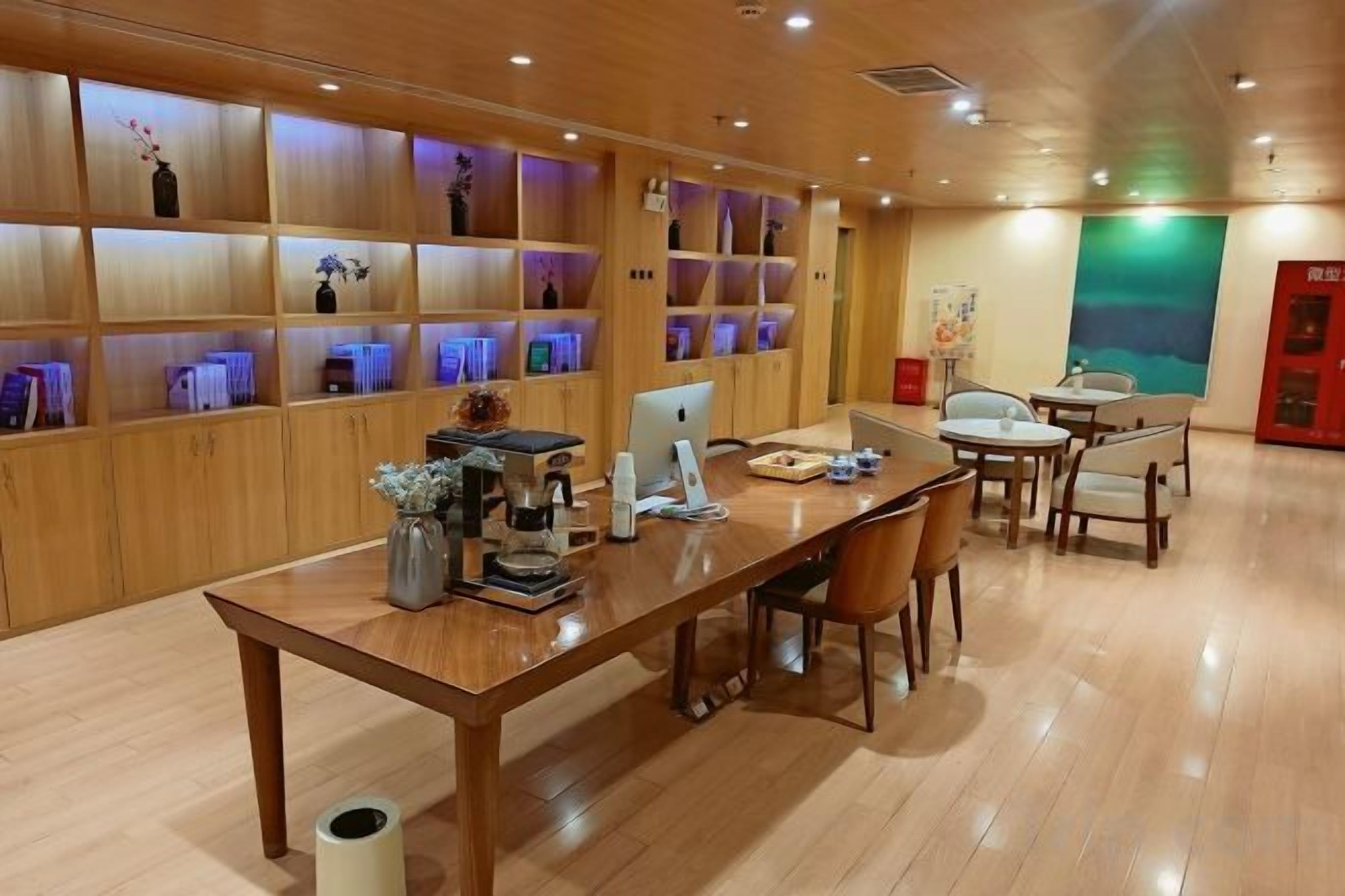 A wooden interior with a long table, chairs, and shelves with items.