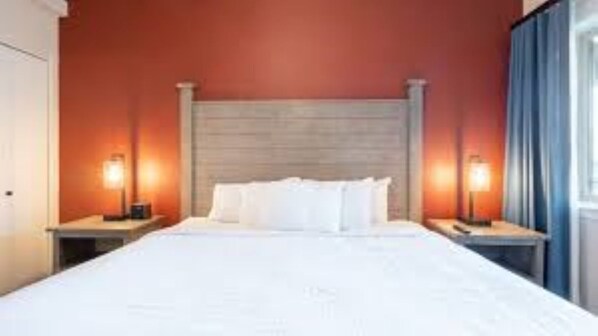 Relax in comfort with a large bed, two nightstands, and a wooden headboard.