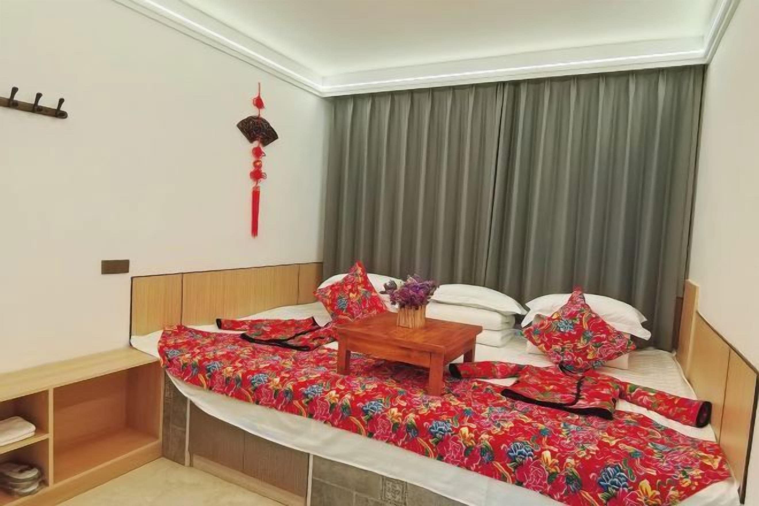 Une chambre à coucher avec un lit, une table de chevet et un rideau.