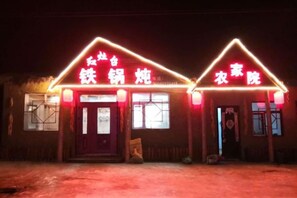 A building with a neon sign indicating a restaurant and a laundry service. - Wuchang Snow Valley Jiaxin Inn (Wuchang)