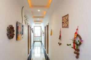 A hallway with a polished floor, decorative wall art, and a ceiling with recessed lighting. - Wuchang Snow Valley Jiaxin Inn (Wuchang)