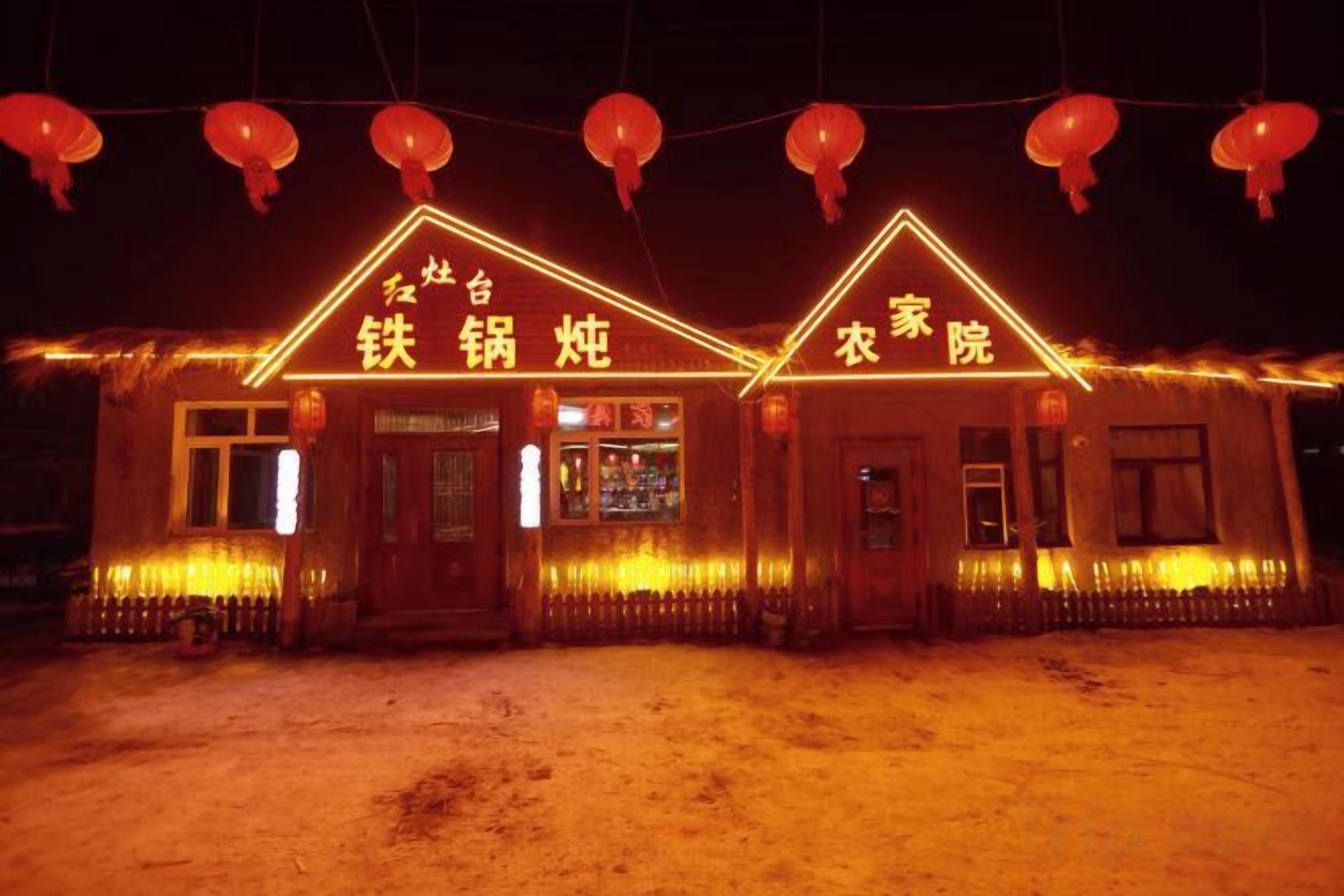 A building with illuminated signage indicating a restaurant and a laundry service.
