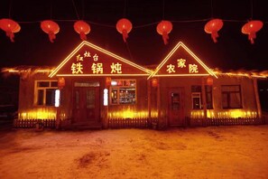 A building with illuminated signage indicating a restaurant and a laundry service. - Wuchang Snow Valley Jiaxin Inn (Wuchang)