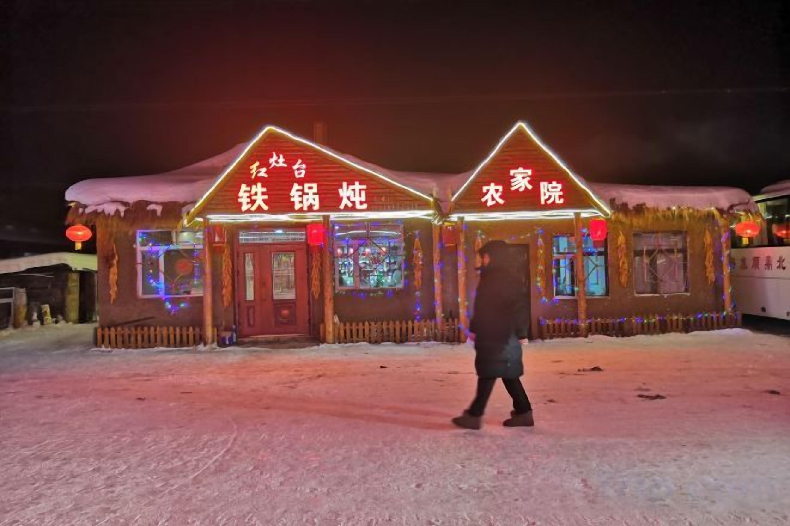 Un edificio con señalización iluminada que indica un restaurante y una posada.