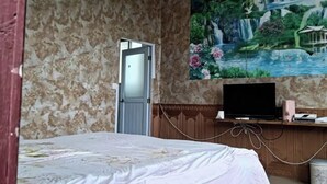 A bedroom with a bed, a TV on a wooden stand, and a large mural of a waterfall and garden on the wall. - Xing'an Mao'er Mountain Bamboo Xiyuan (Xing'an County)