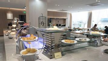 A buffet area with various food items and a seating area.