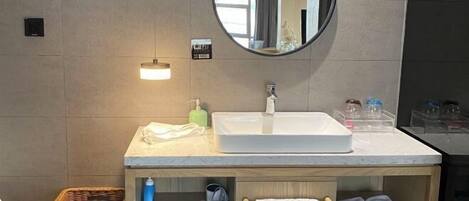 A bathroom with a white sink, a mirror, a towel rack, and a wicker basket.