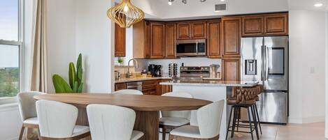 Una cocina moderna con armarios de madera, electrodomésticos de acero inoxidable y una isla central con asientos.