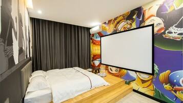 A bedroom with a bed, a large blank screen, and a colorful mural on the wall.