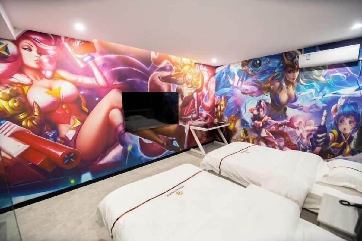 A room with a large mural, a flat-screen TV, and a bed with white bedding.