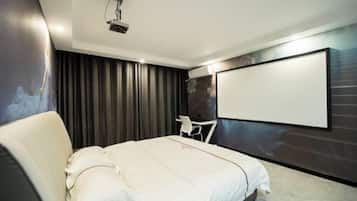 A modern hotel room with a large bed, a flat-screen TV mounted on the wall, and a ceiling projector.