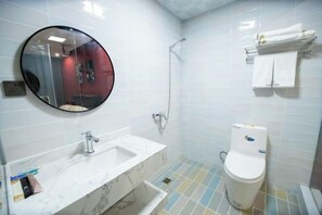 Un baño con lavabo de mármol, inodoro, ducha y espejo.