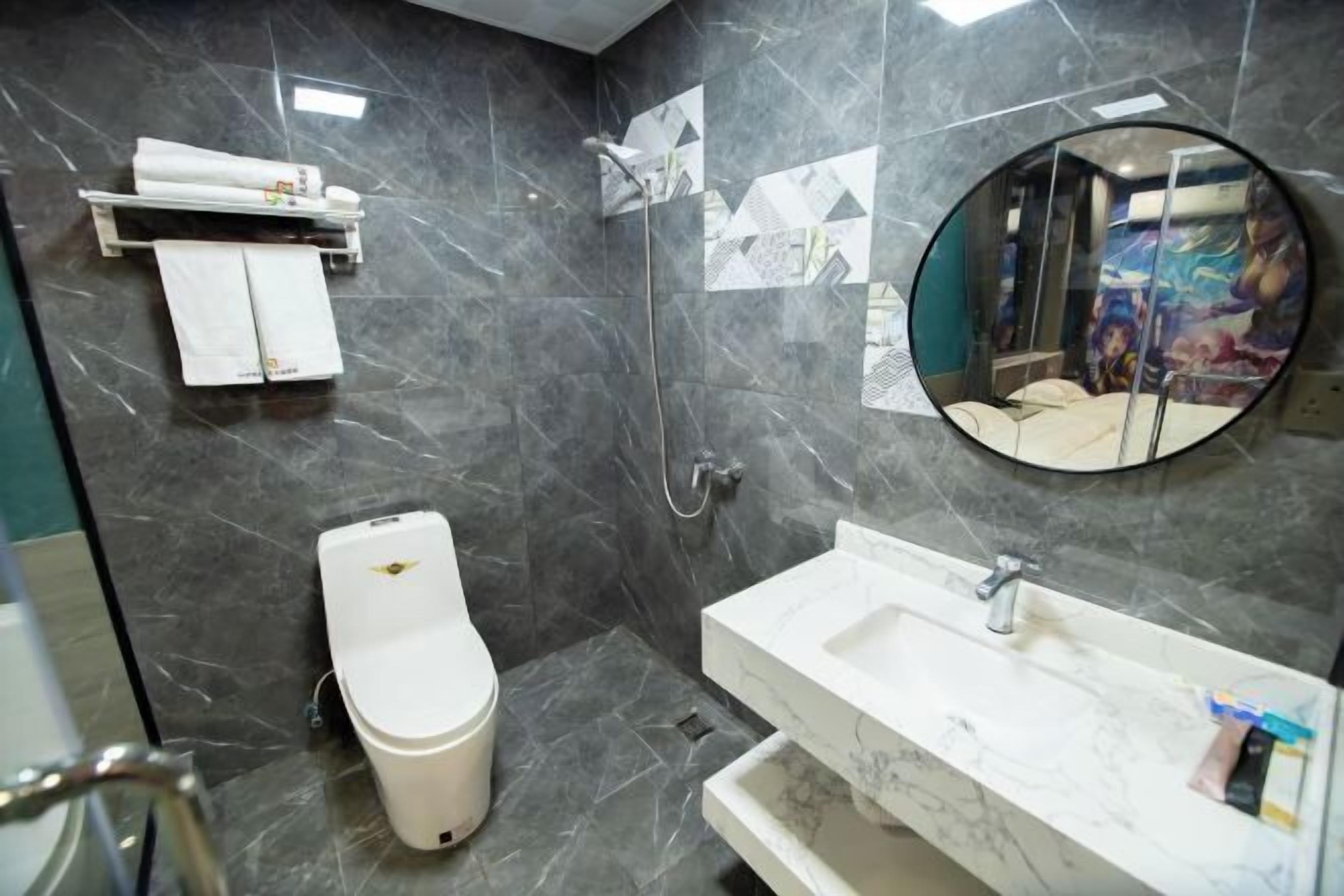 Un baño con inodoro, lavamanos, espejo y ducha.
