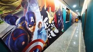 Een gang met een muurschildering van superhelden, waaronder Captain America, en een handgebaar-symbool.
