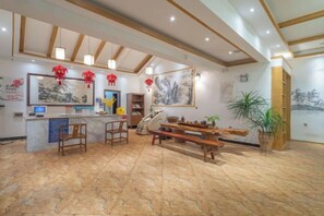 A spacious lobby with a reception desk, seating area, and artwork on the walls. - Sunshine Courtyard Inn (Jianshui Ancient City Branch) (Jianshui)