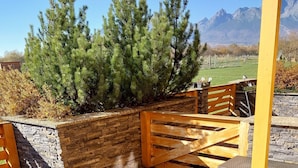 A patio area with a stone wall, wooden fence, and seating.
