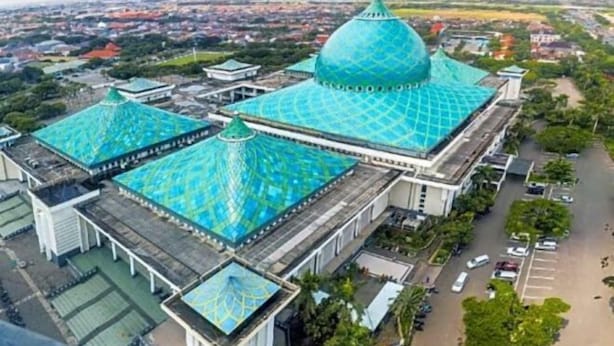 A large building with a distinctive blue dome roof, surrounded by greenery and a parking area. - Regantris Surabaya (Tegalsari)