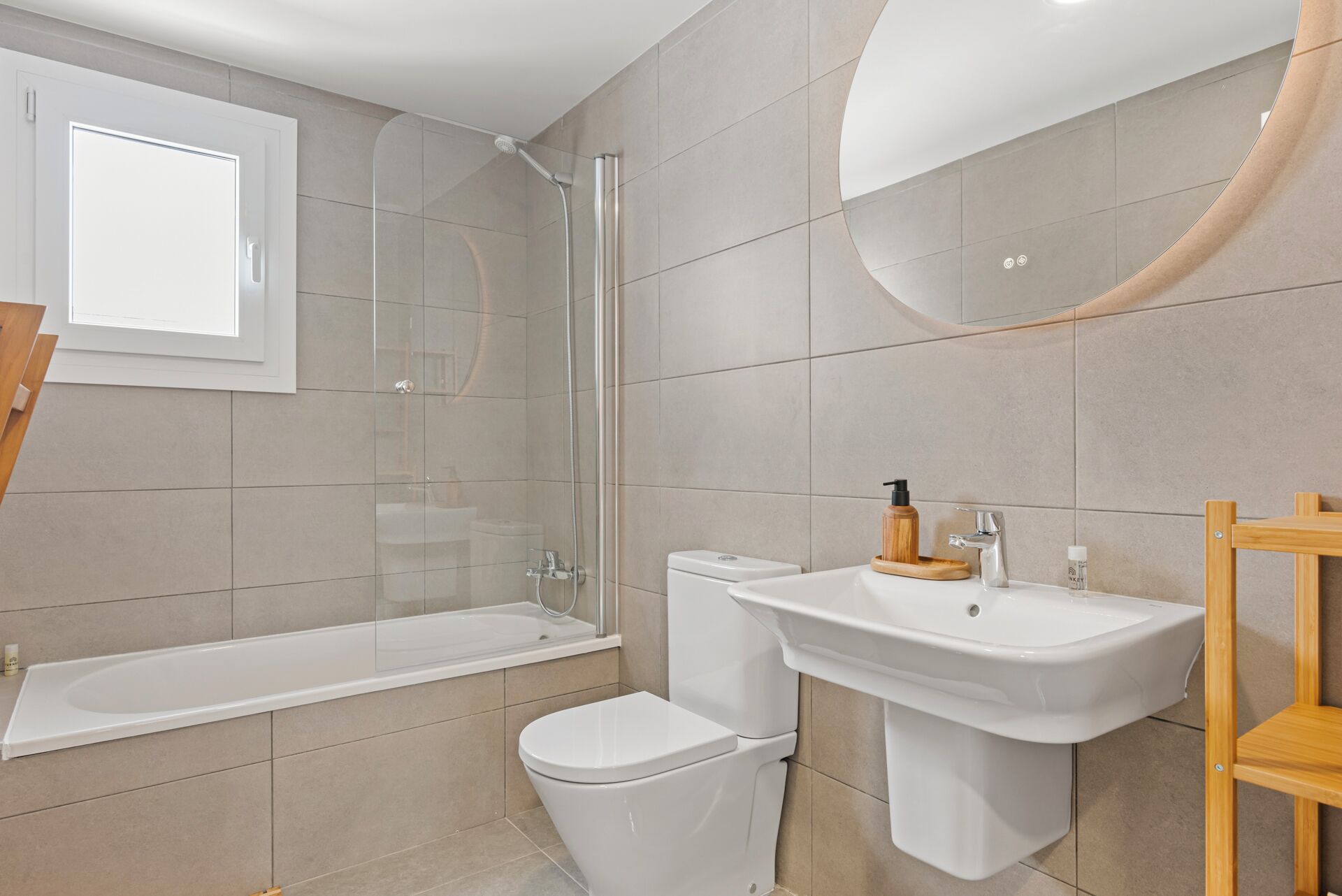 A modern bathroom with a bathtub, toilet, and sink.