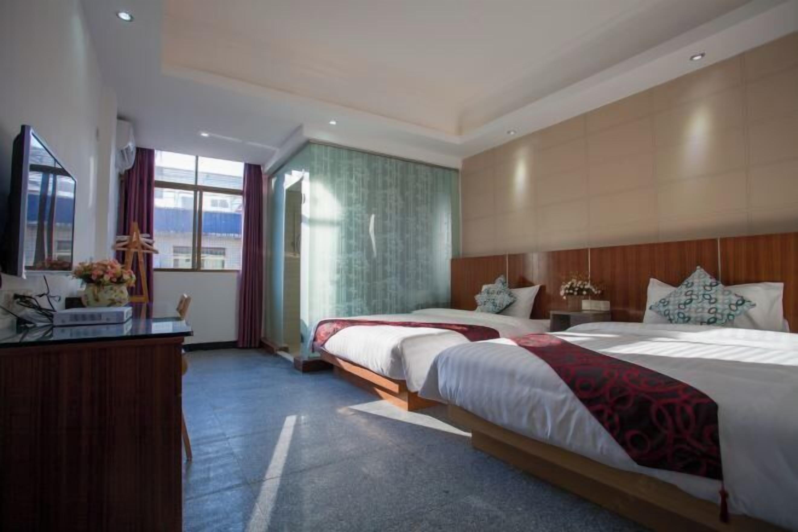 A hotel room with a large bed, a desk, and a view of the city.