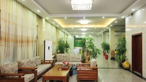A lobby with sofas, a coffee table, and potted plants. - Starry Inn (Renhua)