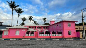 A pink building with a gated entrance and multiple windows.