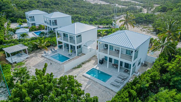 Ein modernes Resort mit drei zweistöckigen Gebäuden, jeweils mit Pool und Außenbereich.